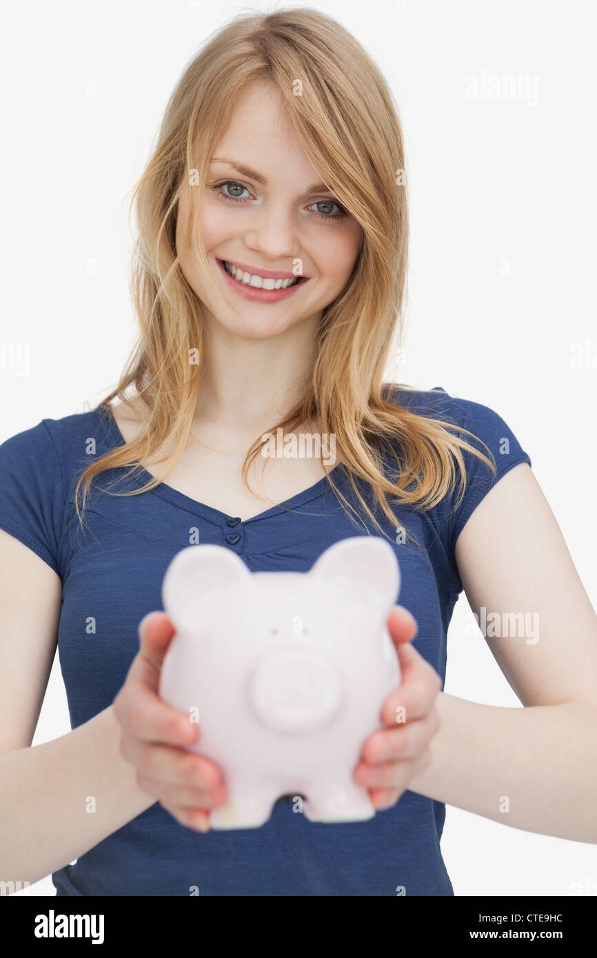 Blonde woman holding a piggy bank Stock Photo - Alamy
