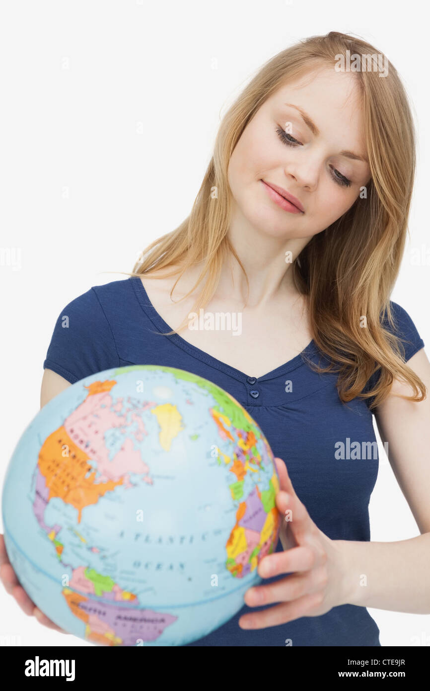 Woman holding a globe while looking it Stock Photo
