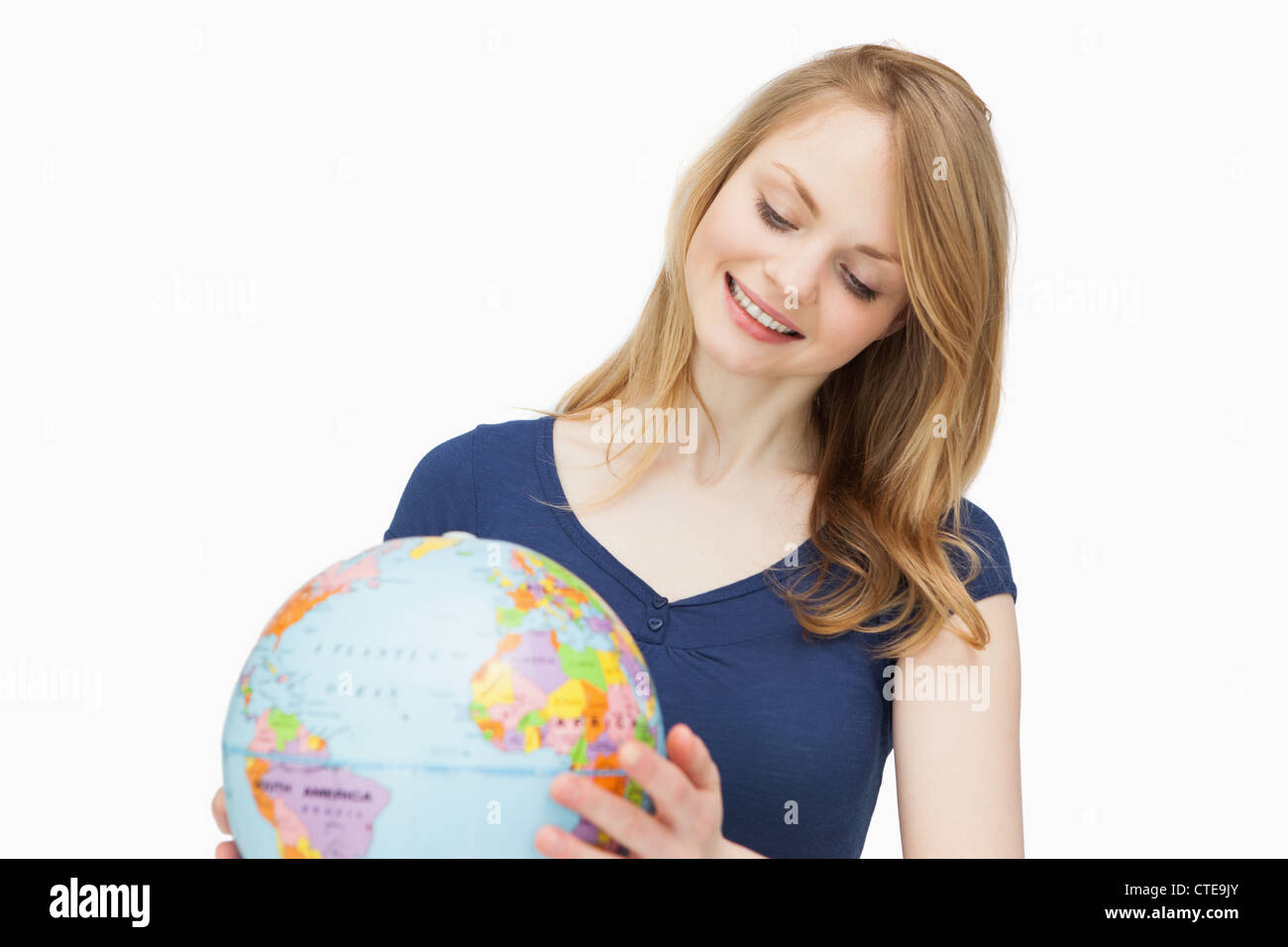 Woman holding a globe while smiling Stock Photo