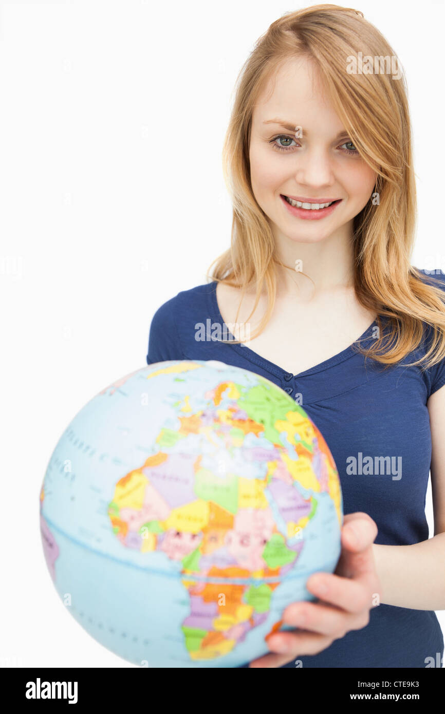 Woman holding a globe while looking at camera Stock Photo