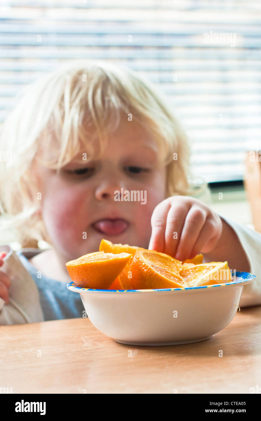 Baby eating fresh orange Stock Photo Alamy