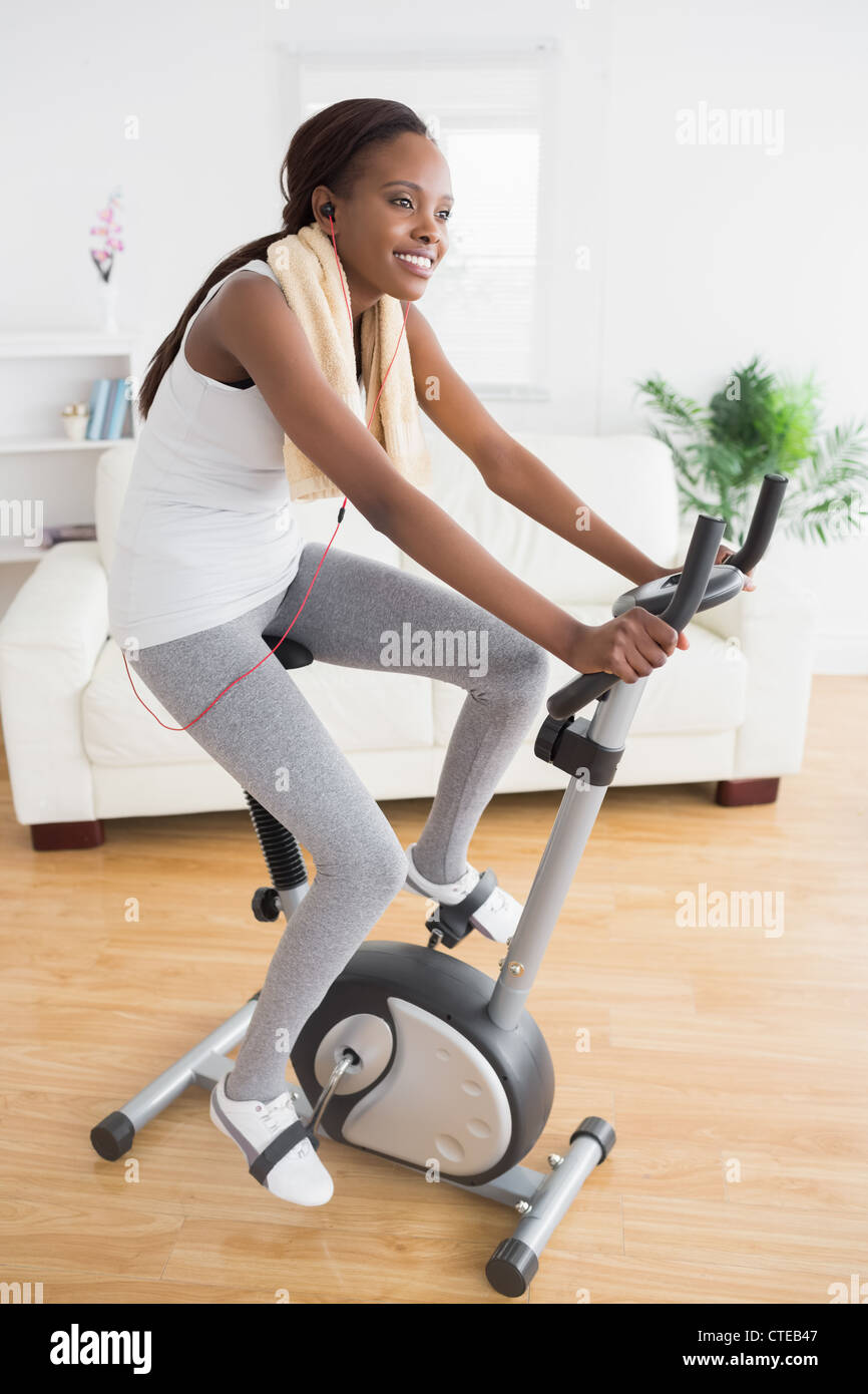 Black woman doing exercise bike while smiling Stock Photo