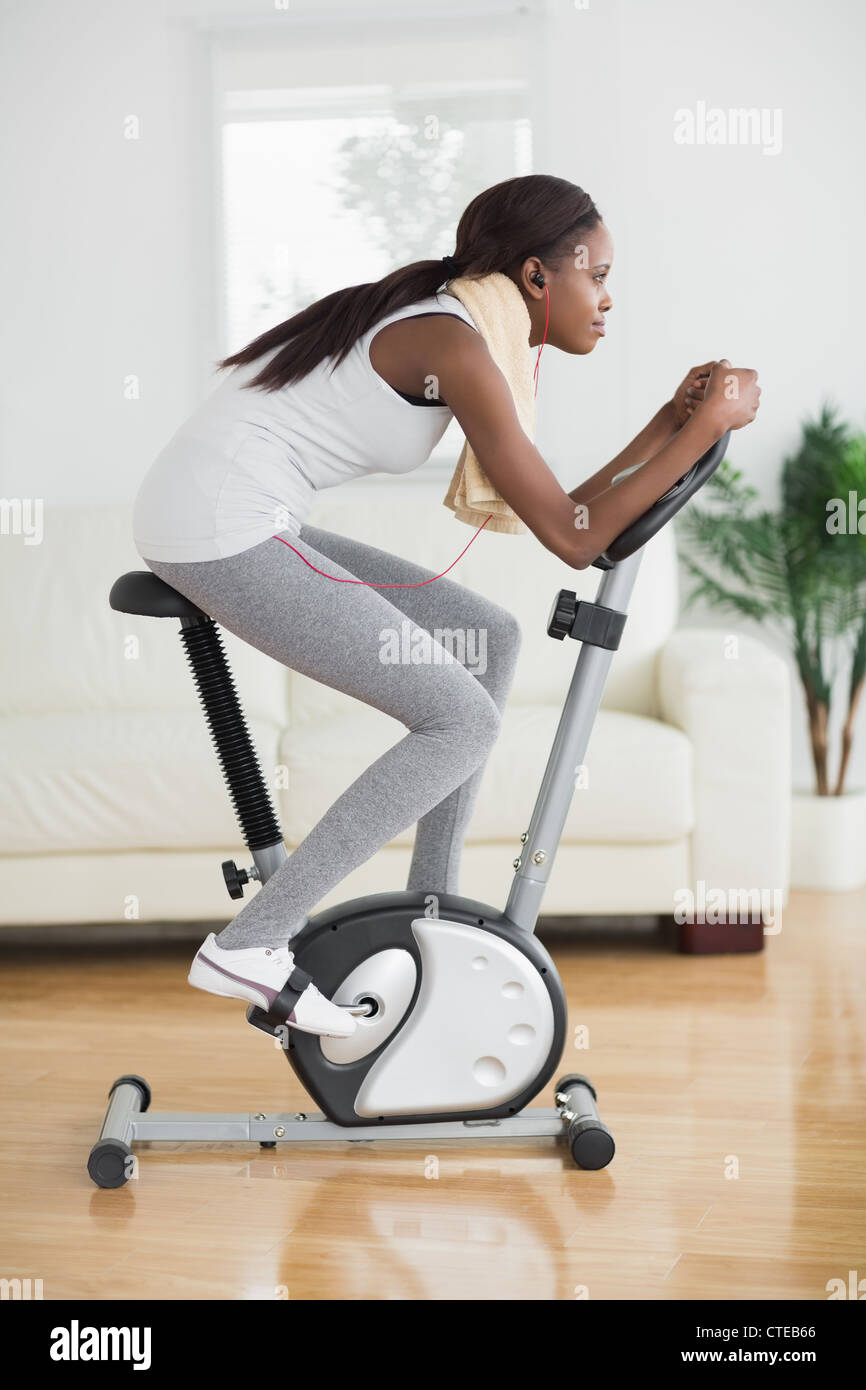 Side view of a concentrated black woman doing exercise bike Stock Photo