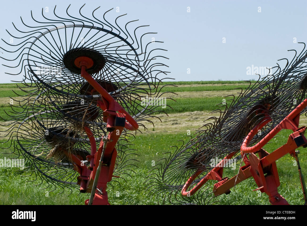 The tines of a modern hay rake show a geometric pattern against the sky. Stock Photo