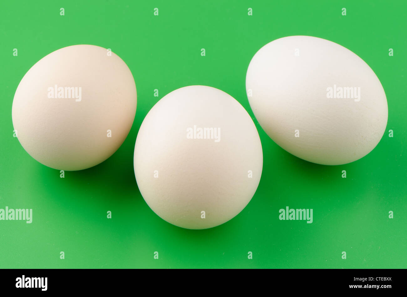 Three brown eggs in green background Stock Photo - Alamy