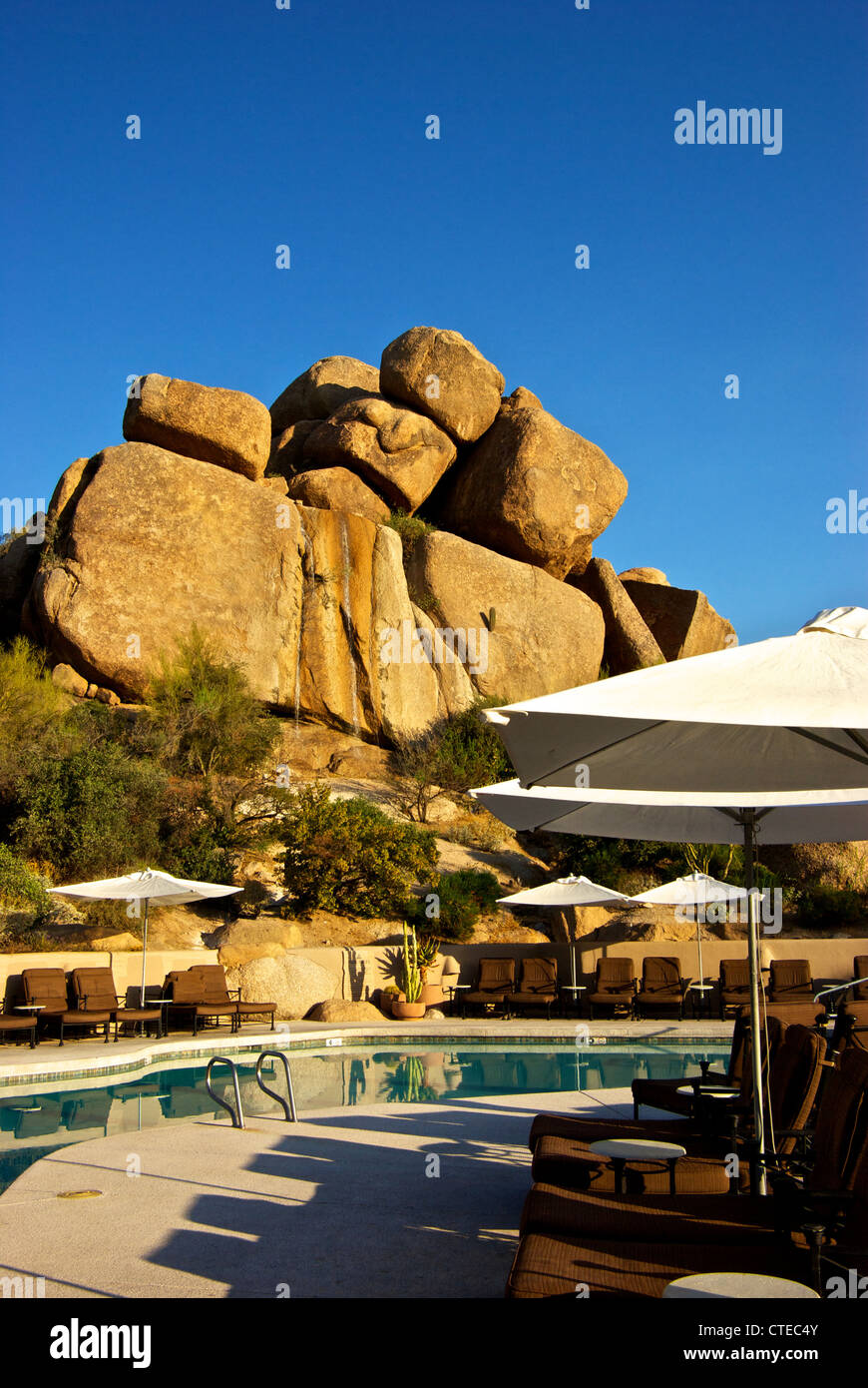 Waterfalls wind eroded granite rock formations form backdrop Boulders Resort pool Scottsdale AZ Stock Photo