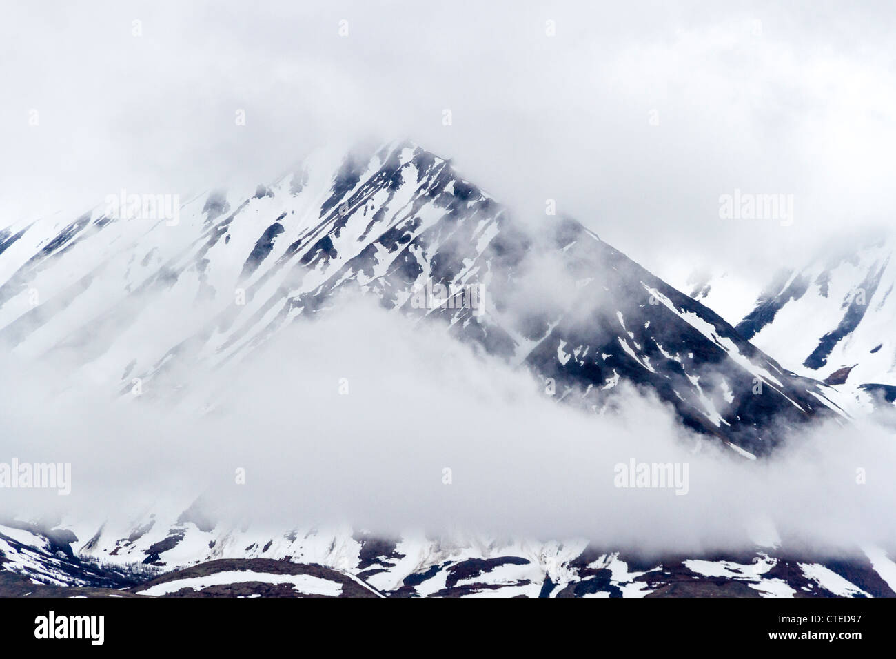 Stormy weather and snow covered mountains in Alaska Mountain Range in 'Denali National Park.' Stock Photo