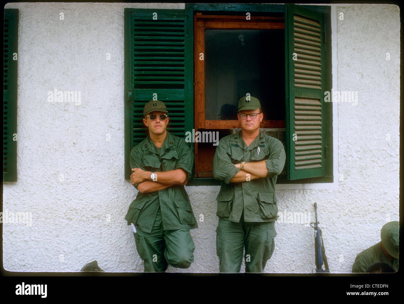 warrant officers standing next to building and m-16 during vietnam war Stock Photo