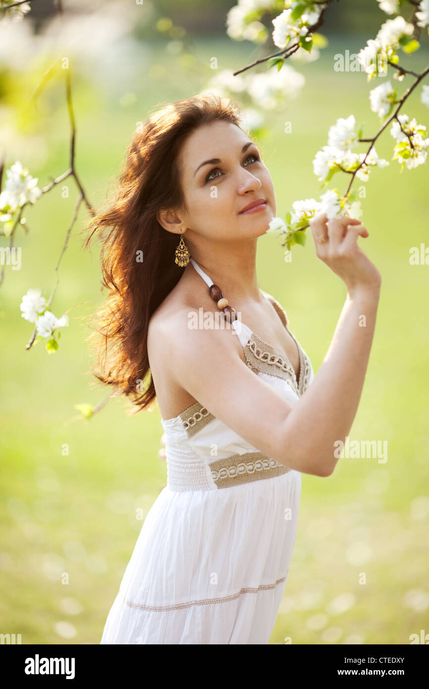 Beautiful woman sitting on the grass in summer park Stock Photo - Alamy