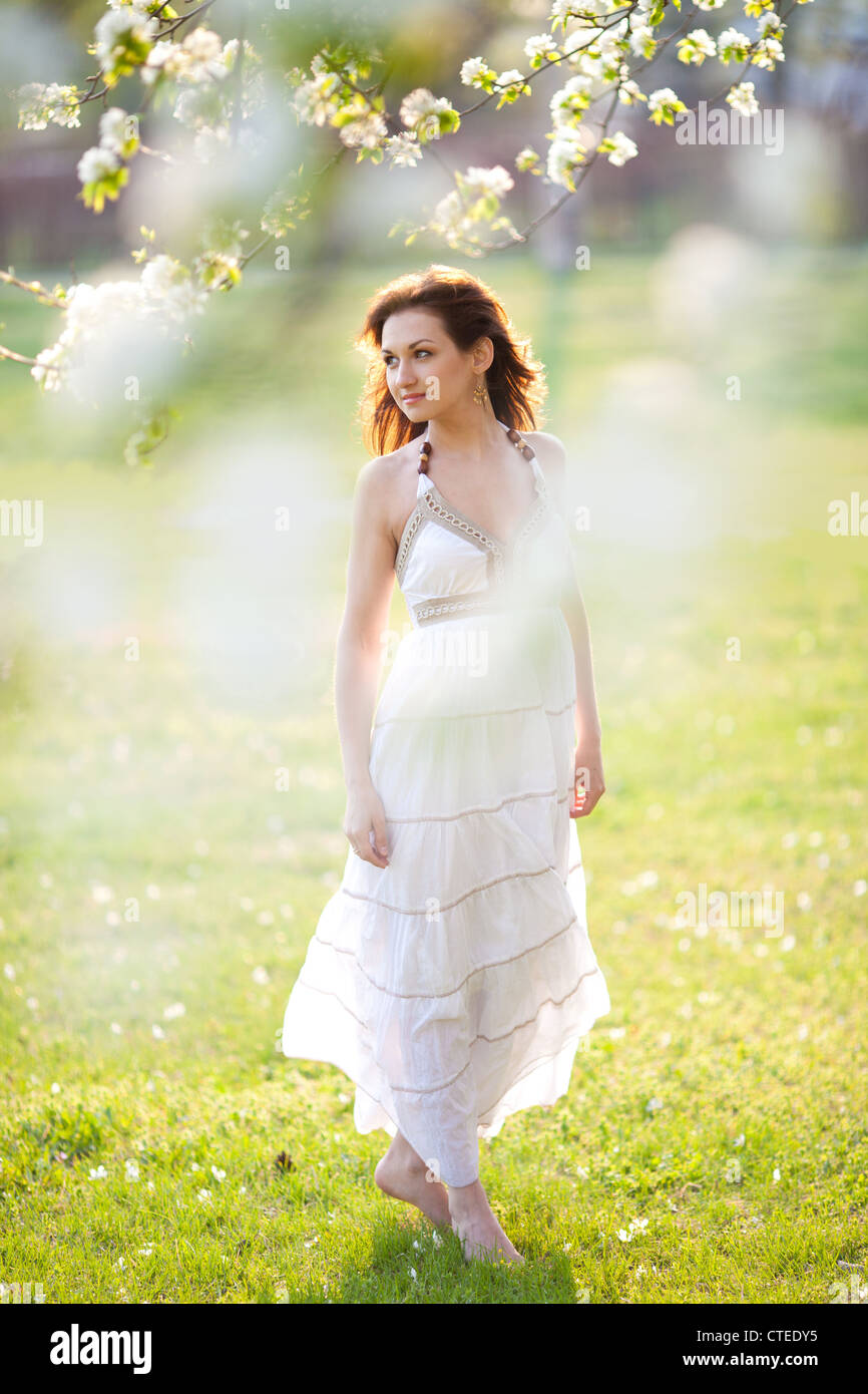Beautiful woman sitting on the grass in summer park Stock Photo - Alamy