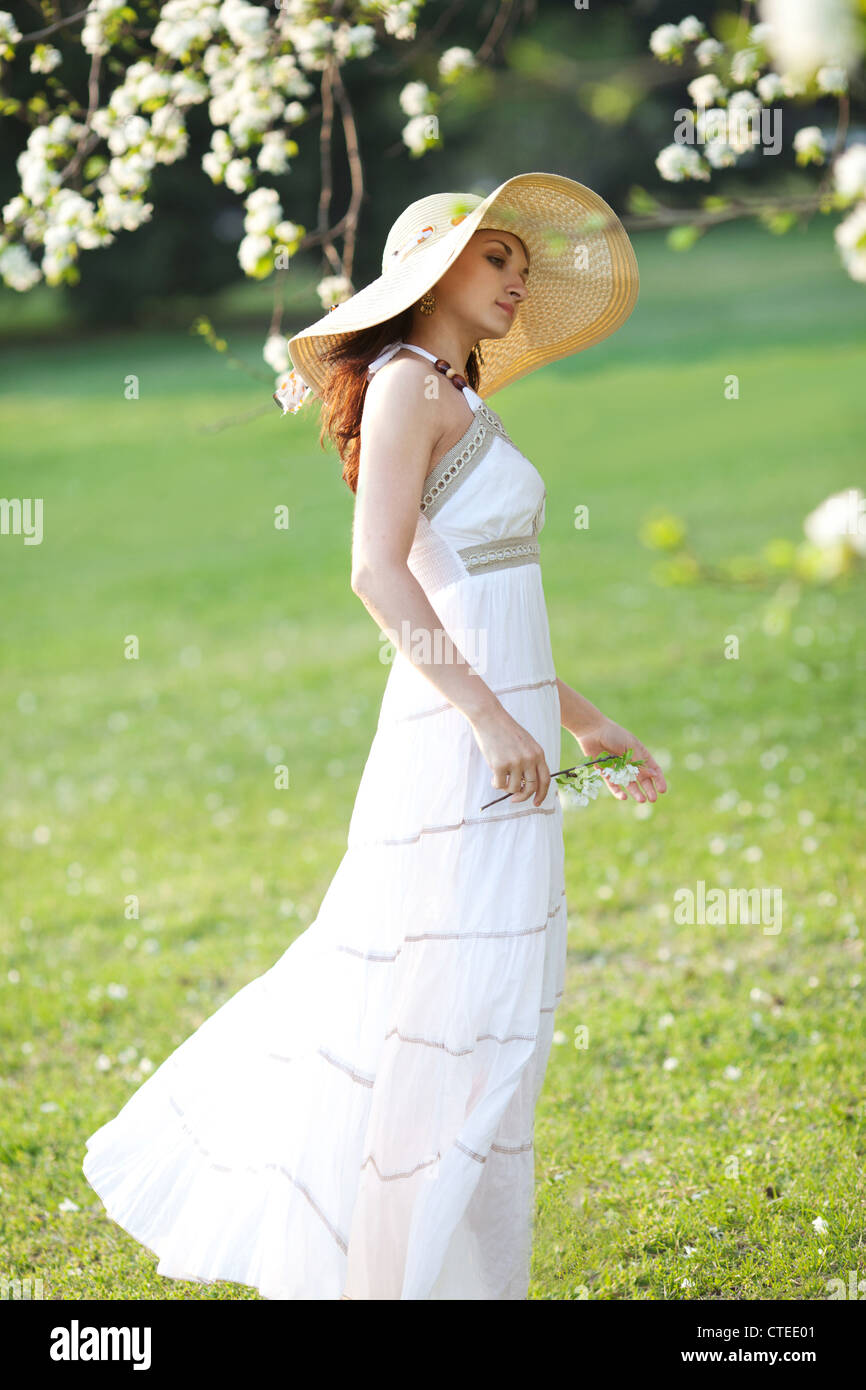 Beautiful woman sitting on the grass in summer park Stock Photo - Alamy