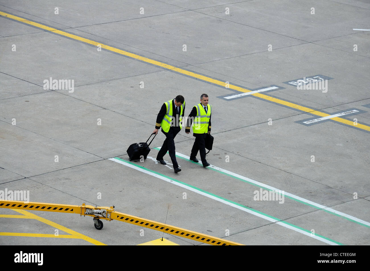 Pilot and co-pilot walking across apron with luggage, Birmingham Airport, West Midlands, England, UK, Western Europe. Stock Photo