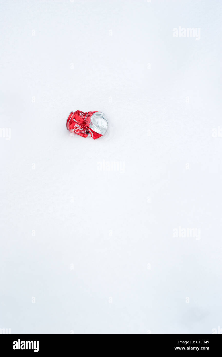 Crushed Coca-Cola can in the snow Stock Photo