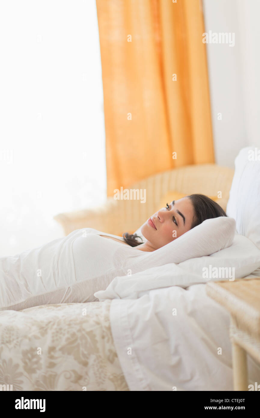 USA, New Jersey, Jersey City, Young woman lying on bed Stock Photo