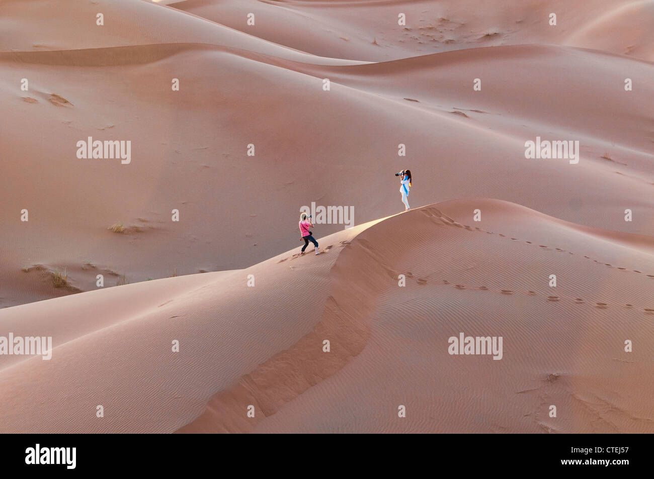 photographers at sunset in the Sahara Desert at Erg Chigaga, Morocco Stock Photo
