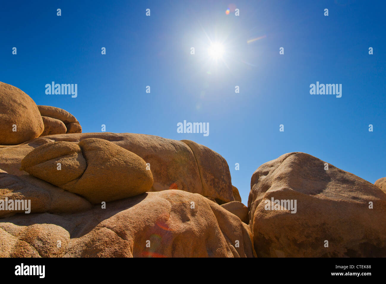 USA, California, Joshua Tree National Park, Desert rocks with solar flare Stock Photo