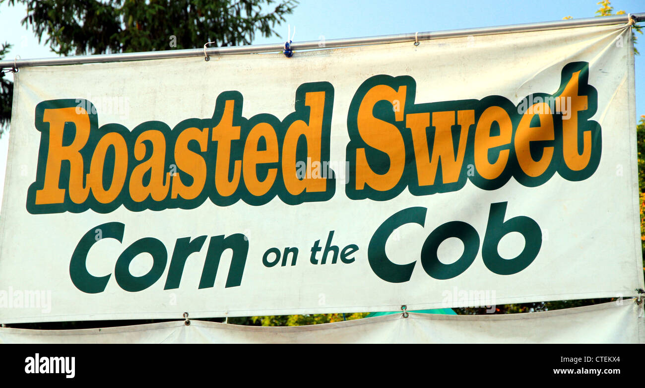 A roasted corn banner sign at an outdoor festival Stock Photo