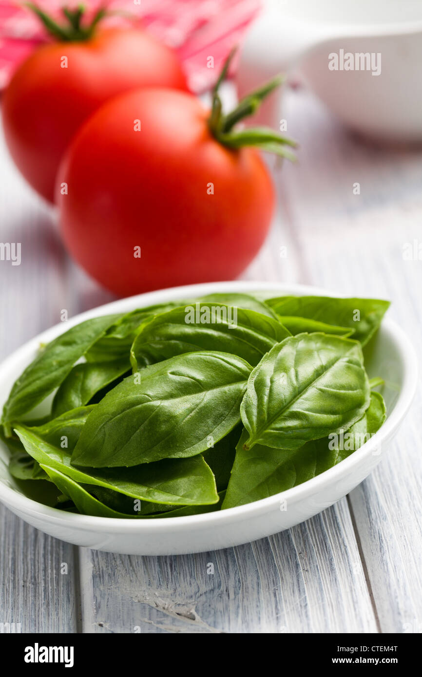 fresh basil leaves and tomatoes on kitchen table Stock Photo - Alamy