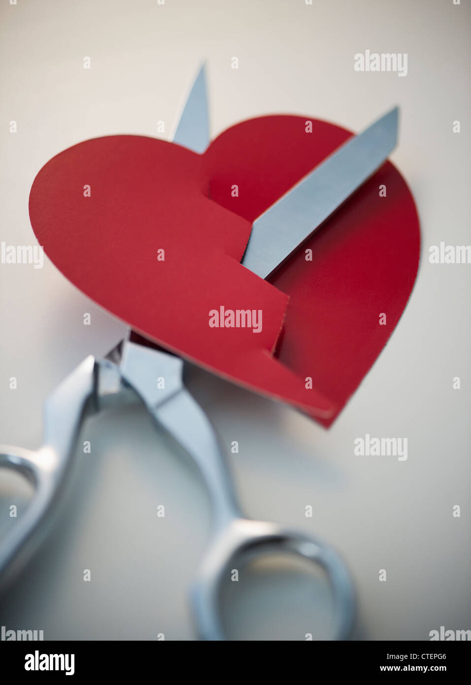 Scissors cutting paper heart Stock Photo