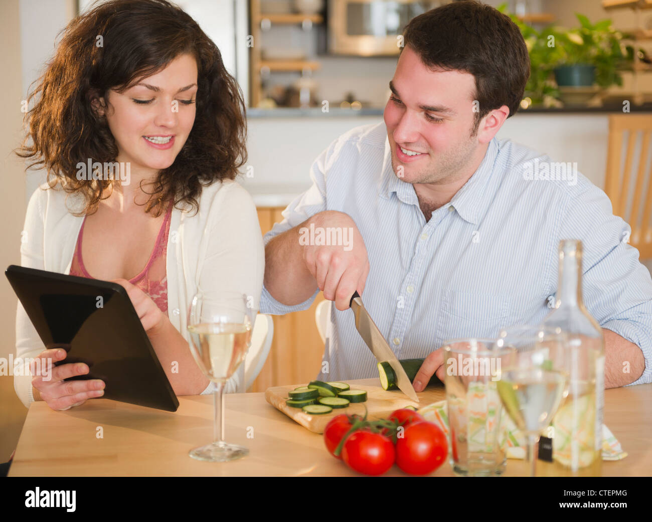 USA, New Jersey, Jersey City, Couple preparing meal and using digital tablet Stock Photo