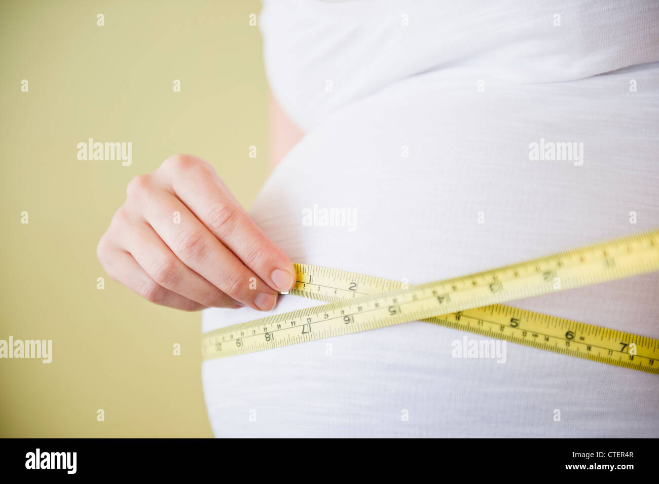 Pregnant woman measuring belly with tape measure Stock Photo Alamy