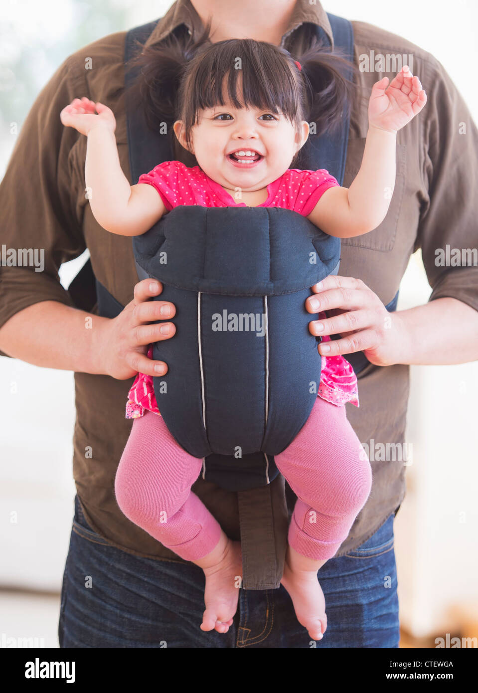 USA, New Jersey, Jersey City, Baby girl (12-17 months) in baby carrier held by her father Stock Photo