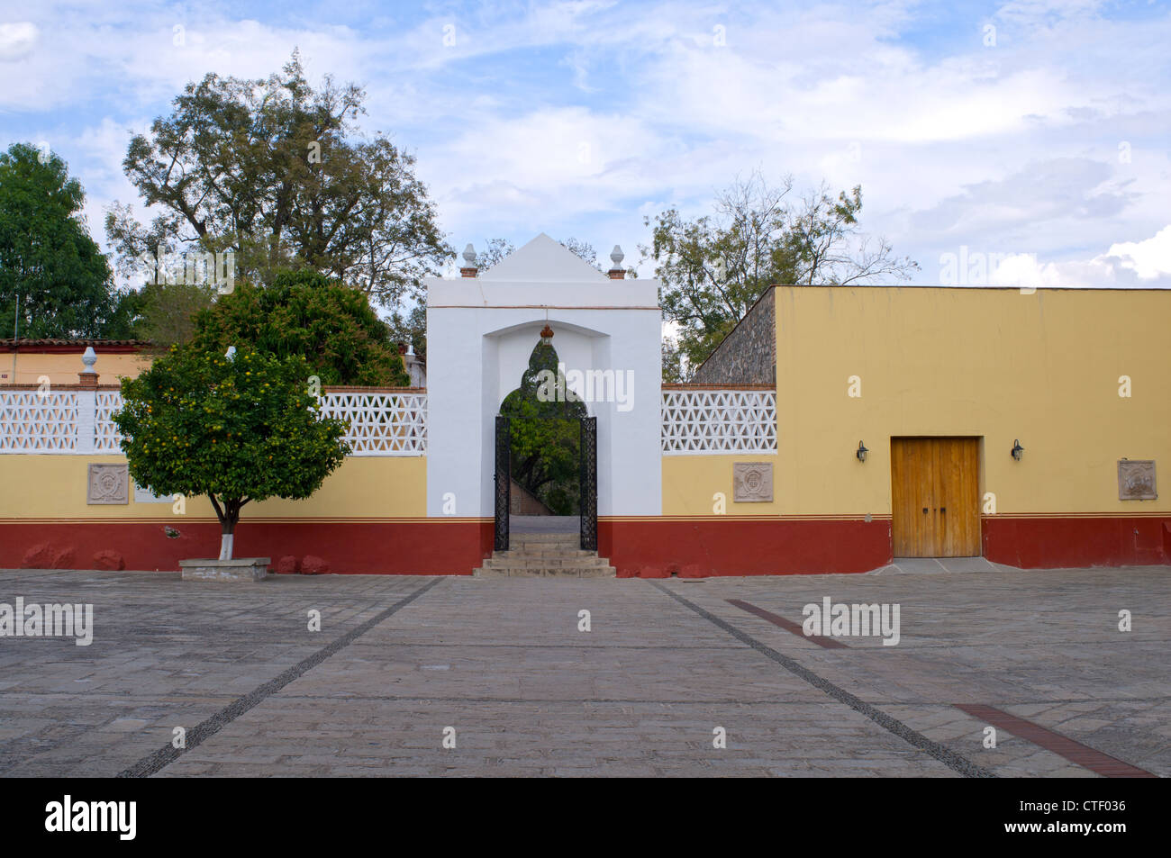 Inside courtyard of Franciscan convent looking toward gated entrance and wall at Amacueca Mexico Stock Photo