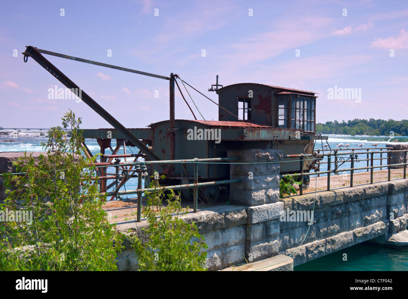 Abandoned and rusted rail crane on bridge at Niagara River just above Horseshoe Falls in Canada Stock Photo
