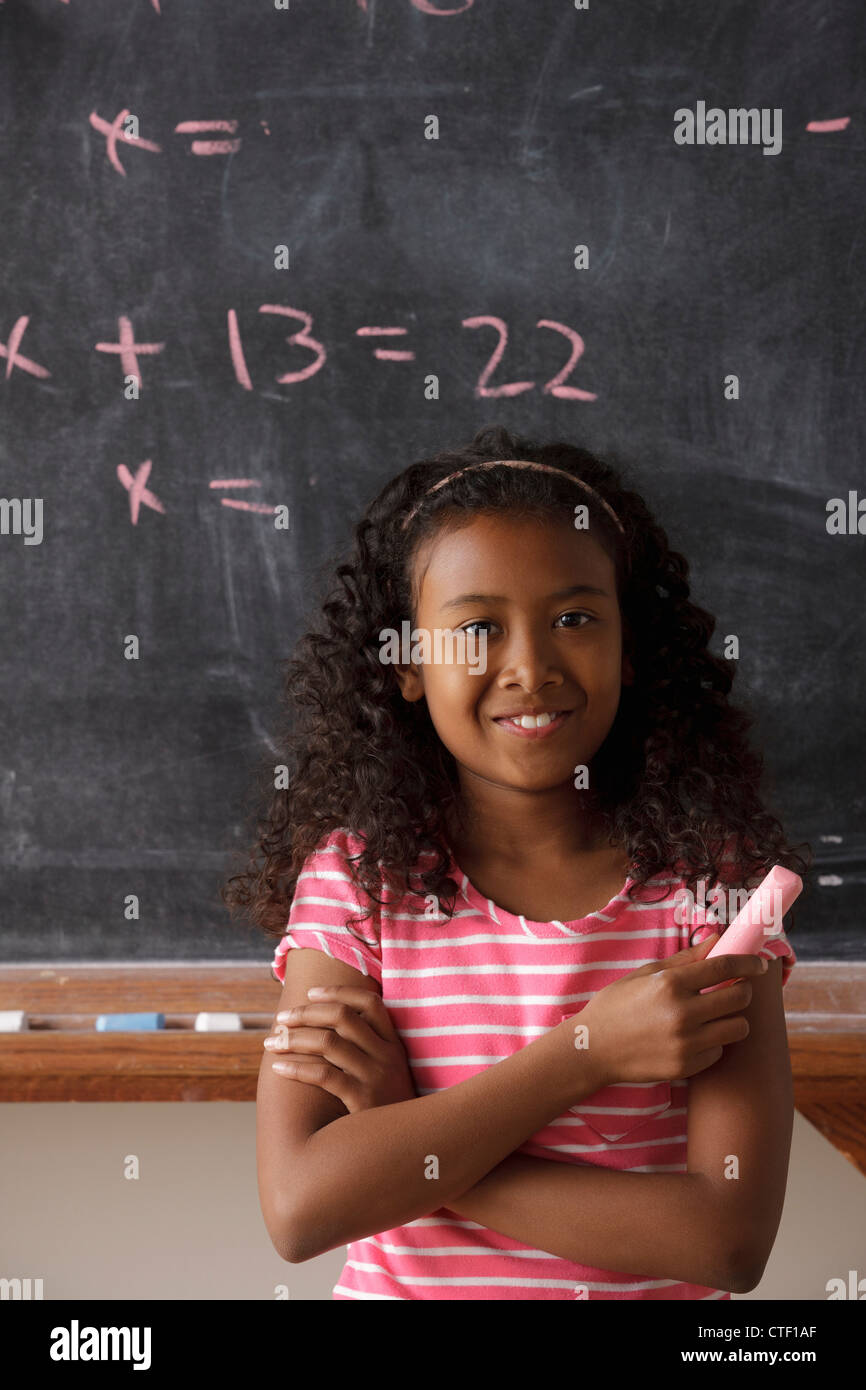 USA, California, Los Angeles, Portrait of schoolgirl (10-11) standing in front of blackboard during math classes Stock Photo
