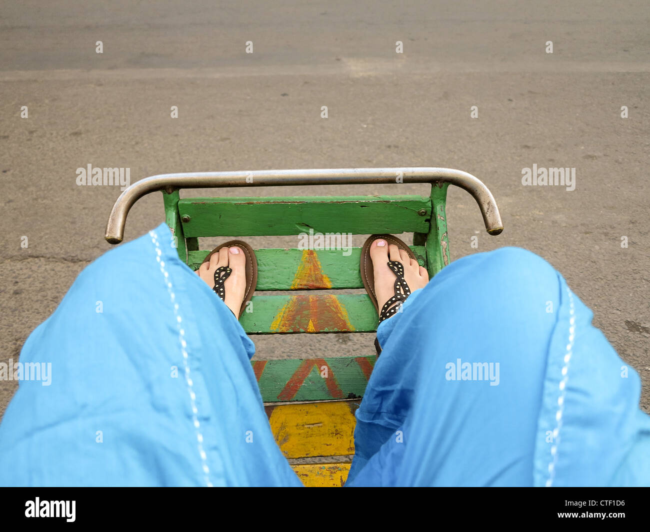 Feet of customer or tourist in the footbed of cyclo in Phnom Penh Cambodia Stock Photo