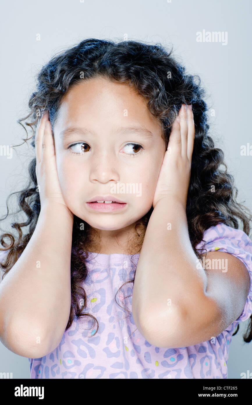 Girl (89) covering her ears, studio shot Stock Photo Alamy