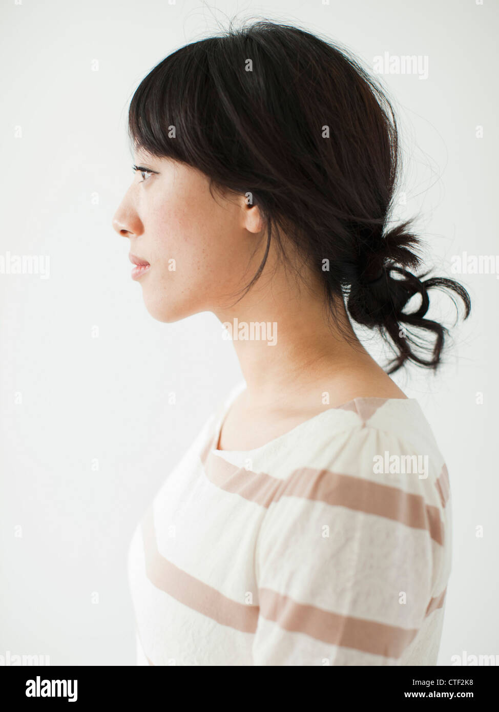Side view of young woman, studio shot Stock Photo
