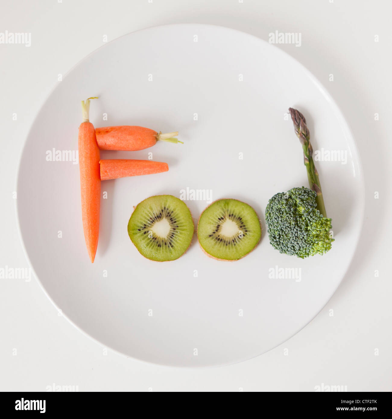 Plate with word 'food' made out of fruits and vegetables, studio shot