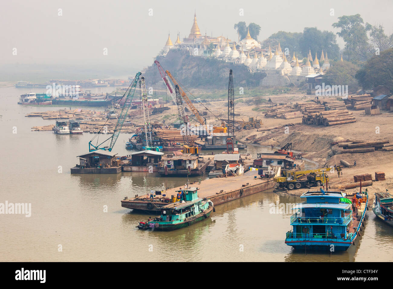 Log transport operation and Shwe-kyet-kay Buddhist Temple on the Irrawaddy River near Sagaing Myanmar Stock Photo