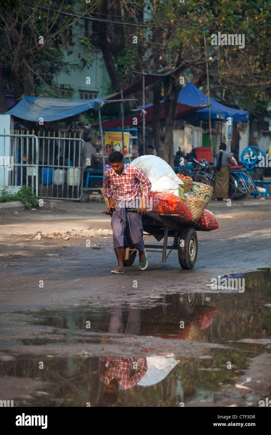 Man pulling a cart of vegetables in Mandalay, Myanmar Stock Photo