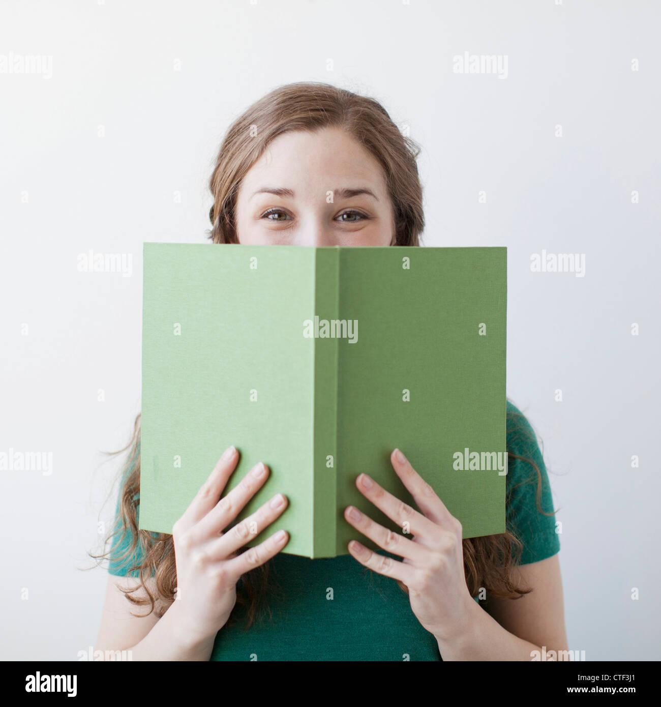 Happy young woman holding green book Stock Photo