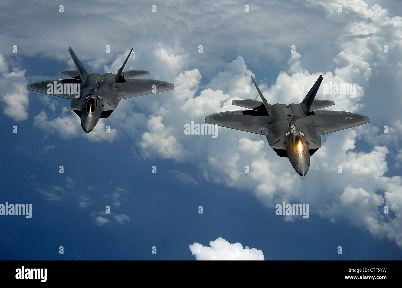 Two US Air Force F-22 Raptor fighter aircraft fly behind in formation July 10, 2012 over Joint Base Andrews, Maryland. The Raptors is the newest aircraft in the Air Force fleet. Stock Photo