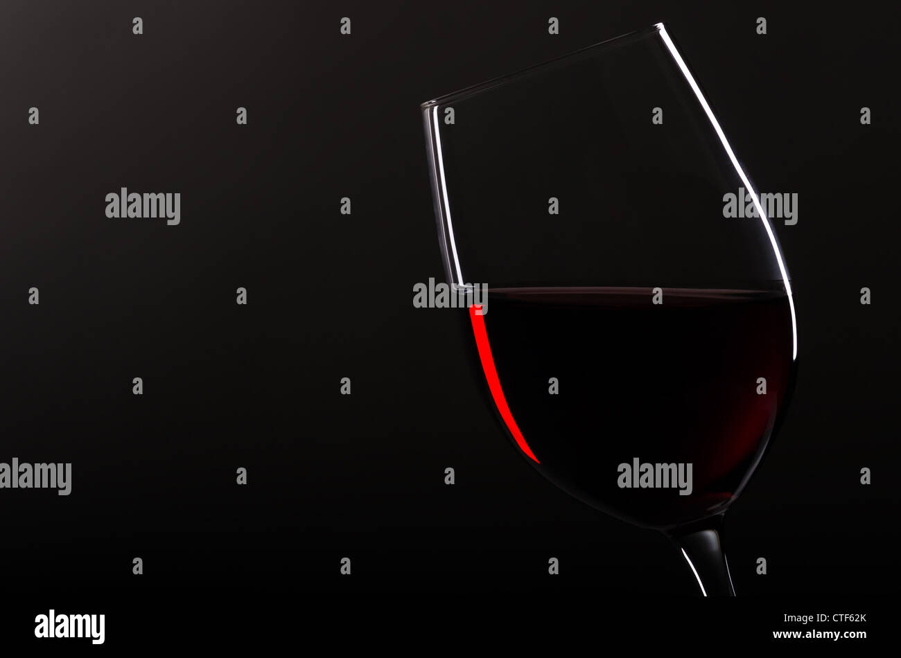 one wineglass with redwine before black background Stock Photo