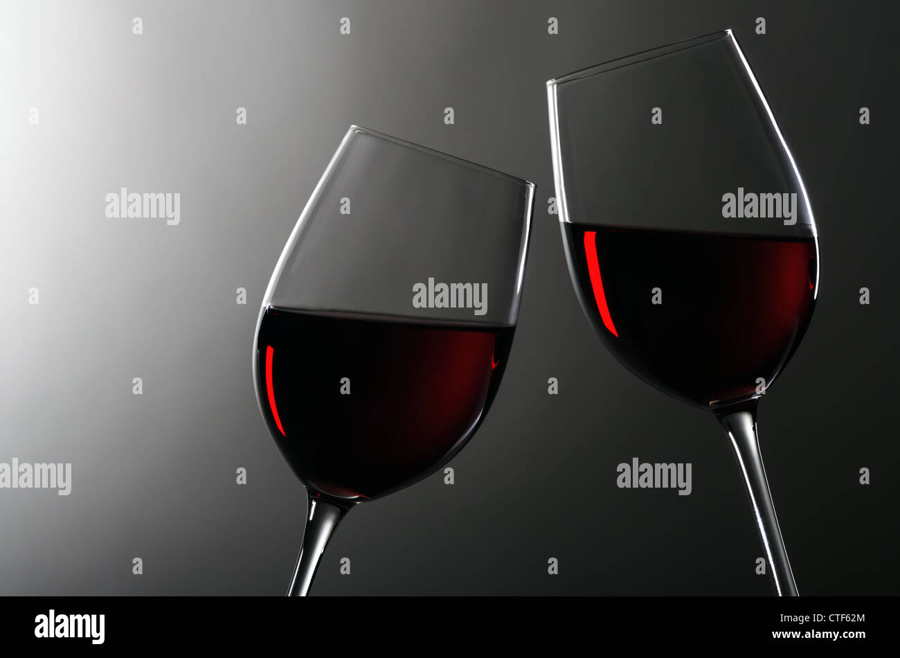 two wineglasses with redwine stay together Stock Photo