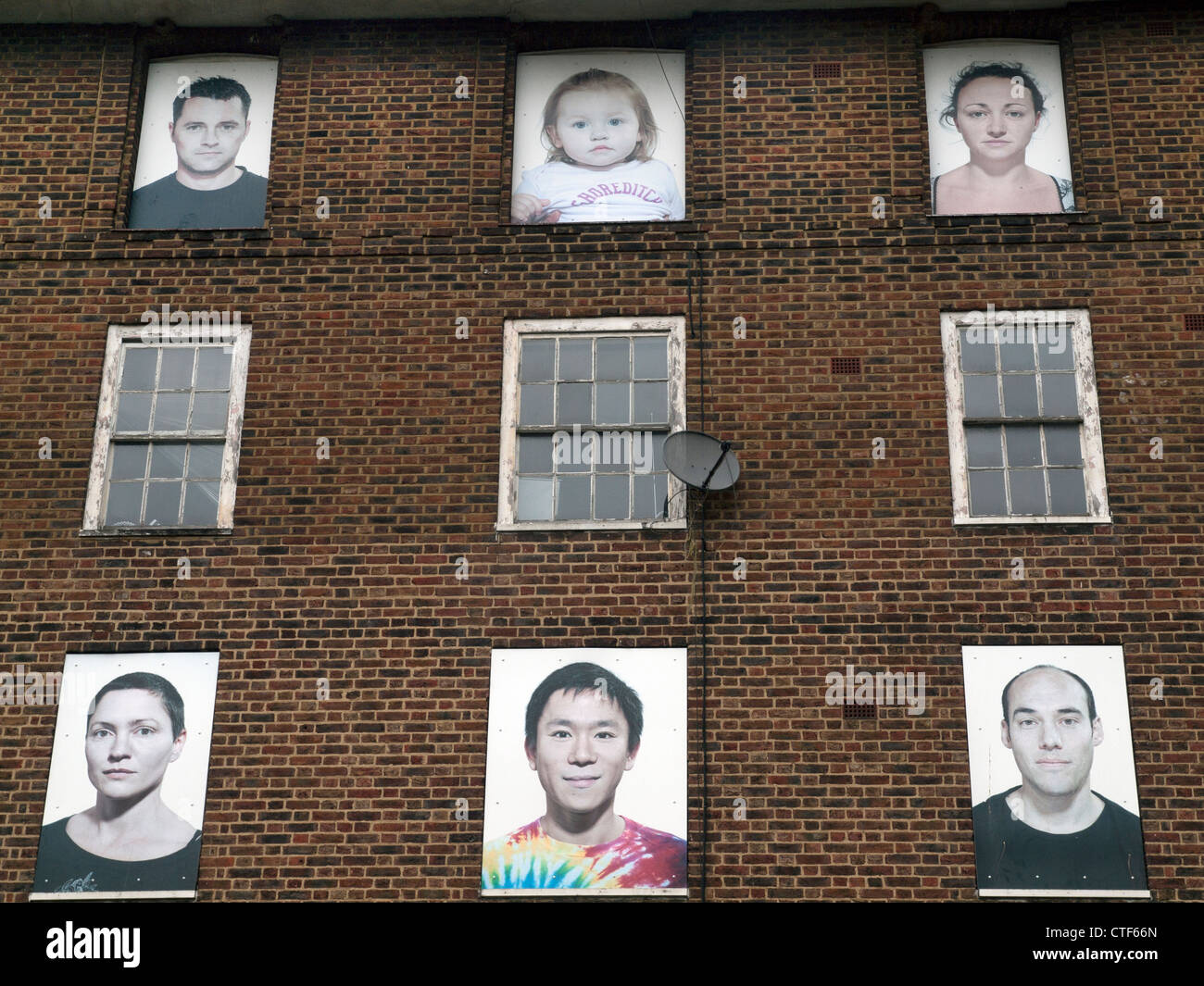 Faces upon the windows of a no longer occupied housing estate awaiting demolition in Hackney,London. Stock Photo