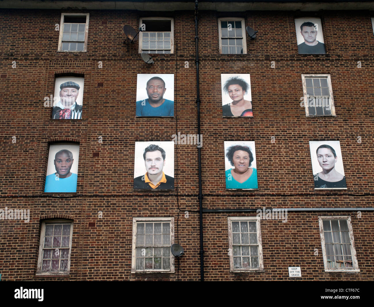 Faces upon the windows of a no longer occupied housing estate awaiting demolition in Hackney,London. Stock Photo