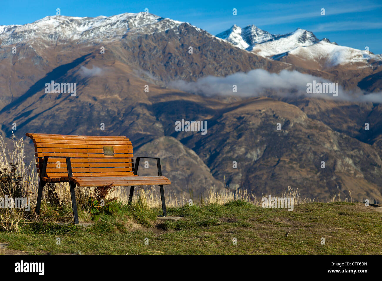 Bench overlooking the Remarkables mountains above Queenstown, New Zealand Stock Photo