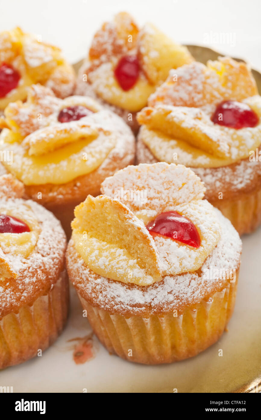 A traditional sweet treat for afternoon tea, butterfly buns or cakes with lemon butter cream and cherries, Stock Photo