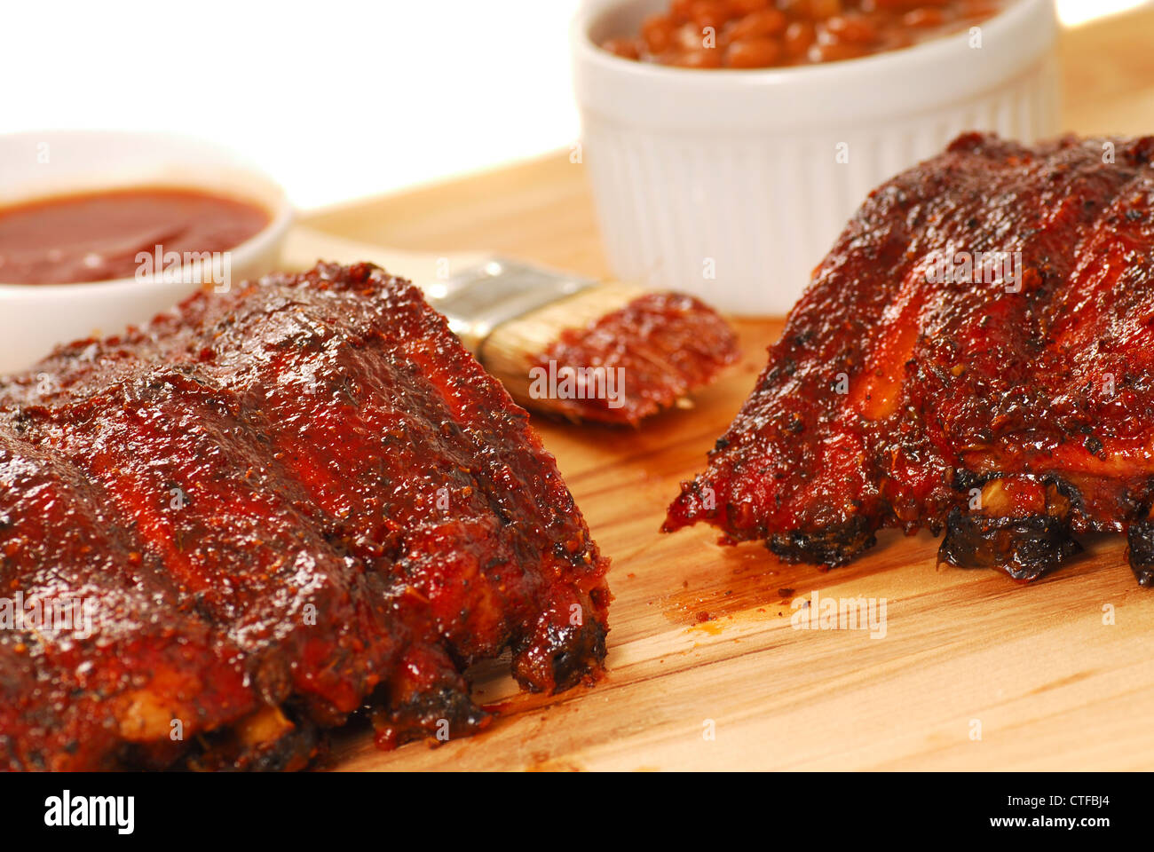 Slab of BBQ spare ribs with beans and dipping sauce Stock Photo Alamy