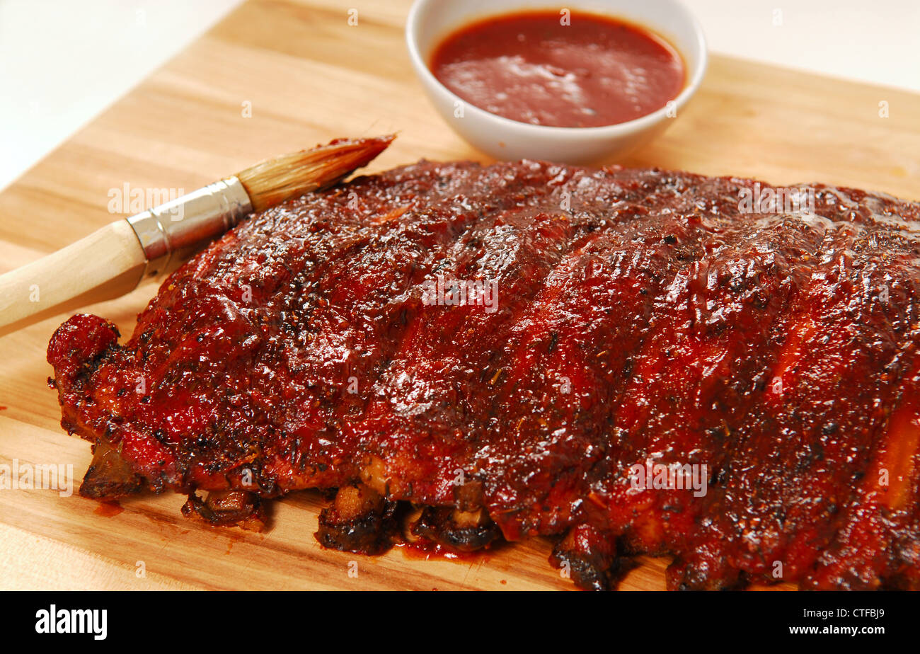 Slab of freshly grilled BBQ spare ribs with dipping sauce Stock Photo