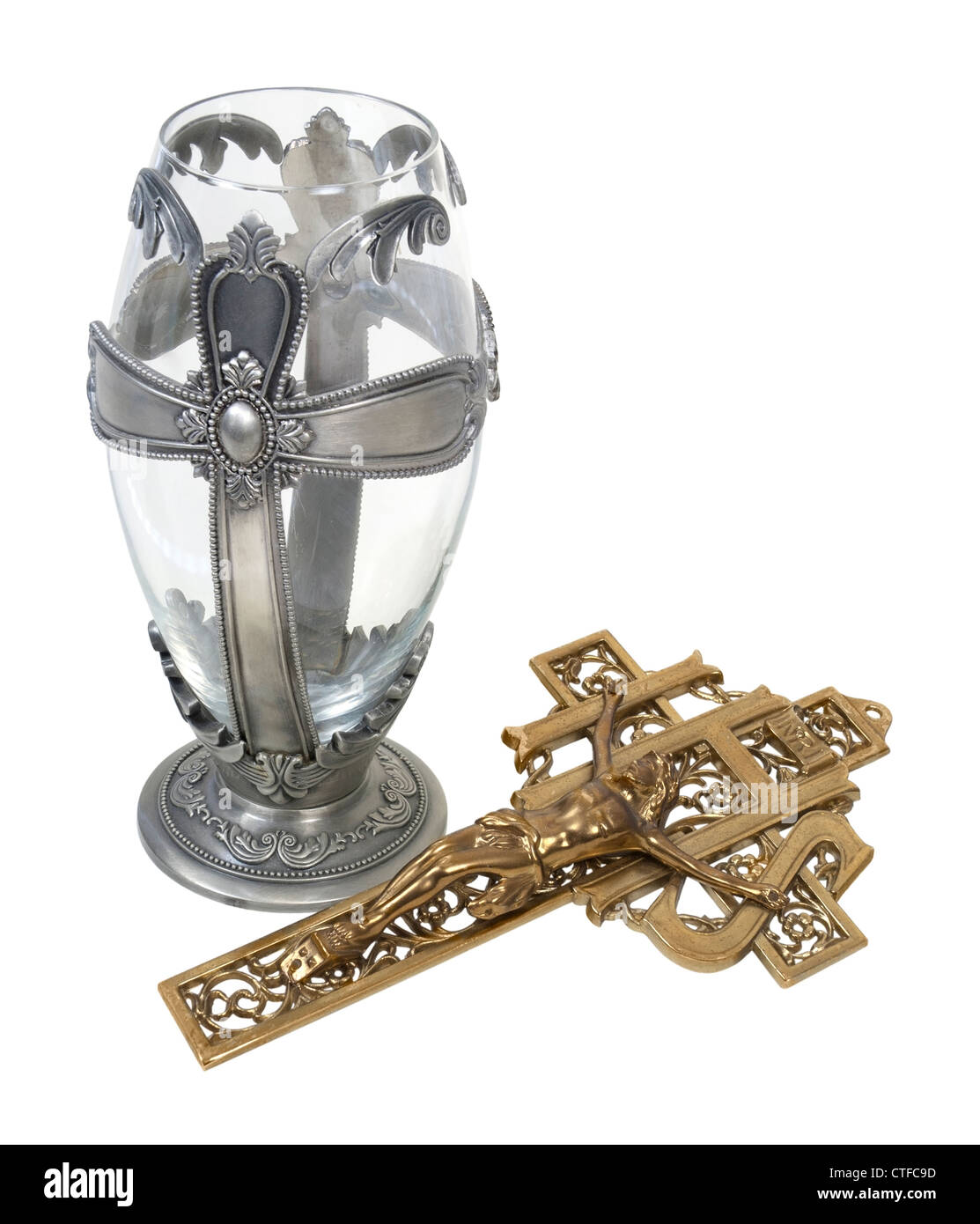 Silver cross chalice and a brass crucifix which are Catholic religious symbols - path included Stock Photo