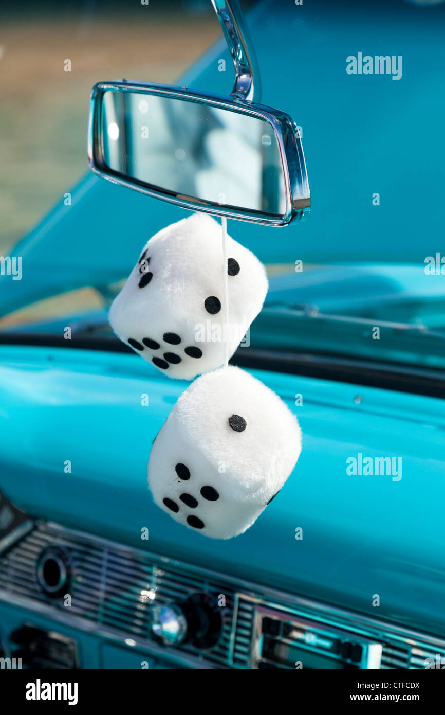 Dice hanging from rearview mirror of antique restored automobile