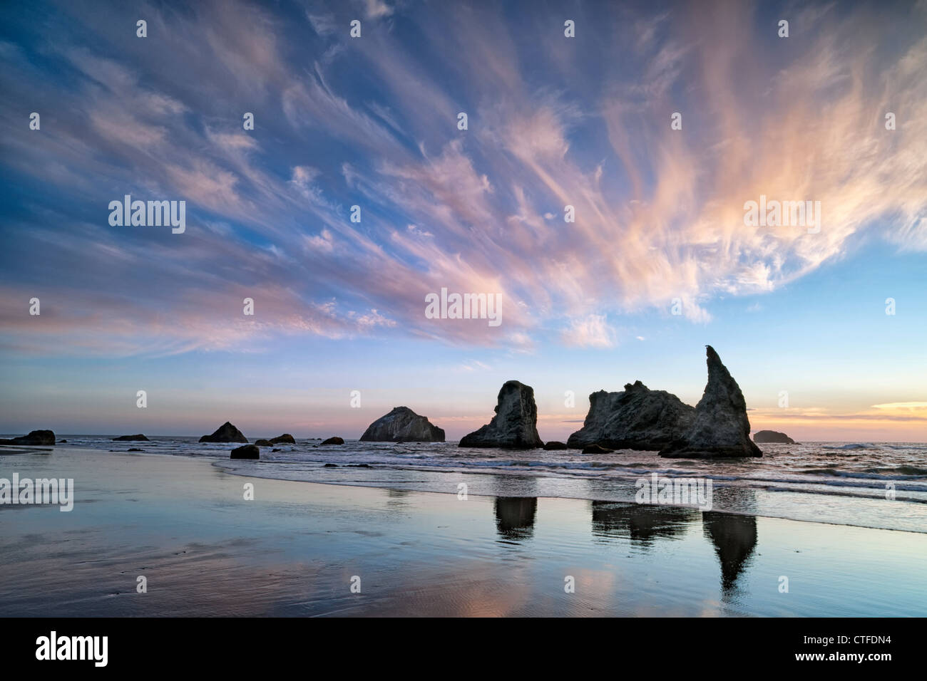 Sunset reflections of offshore Face Rock and sea stacks along Oregon’s ...