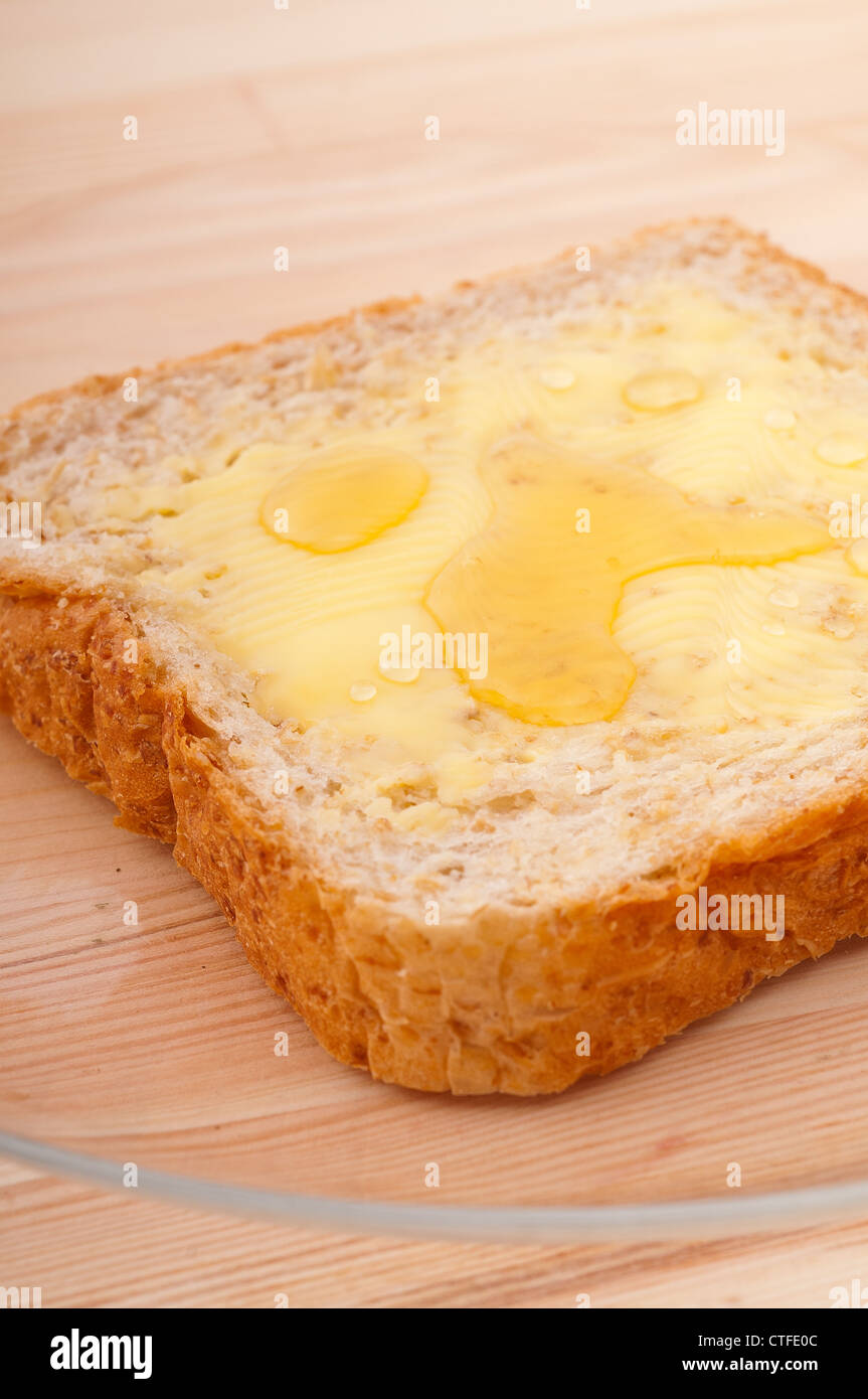 slice of whole grain bread with butter and honey Stock Photo Alamy