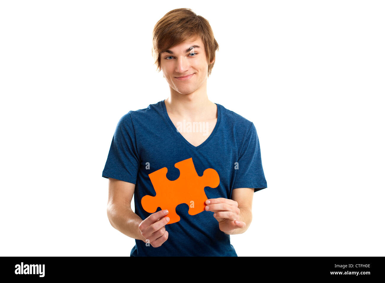 Young man holding a puzzle piece isolated on white background, solution concept Stock Photo